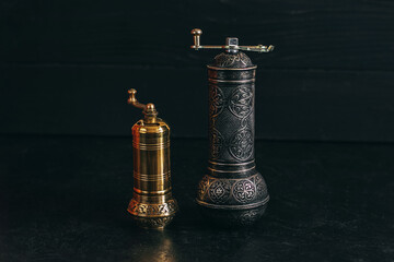 Pepper or coffee vintage metal grinder on a dark black background