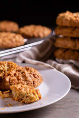 Freshly baked warm oatmeal cookies on a cooling rack on a dark background
