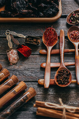 Colorful various spices in wooden spoons on old dark background. Top view with free space