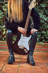 Rocker woman posing with a guitar.
