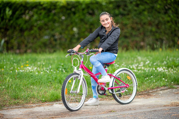 Happy young girl on teh bicycle outdoor