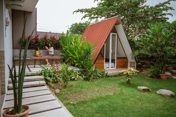 Tropical Garden backyard during the day with wooden cabin