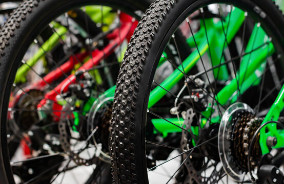 Photo of bikes standing in store close-up wheels and tires view.