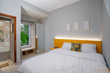 White pillows on wooden bed in minimal bedroom interior with window