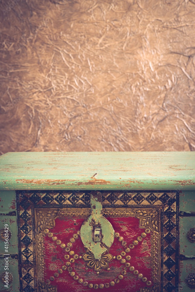 Poster fragment of a decorated old treasure chest and a beige, brown wall with texture. empty space for tex