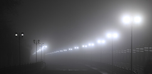 city canal at night in fog with street lights