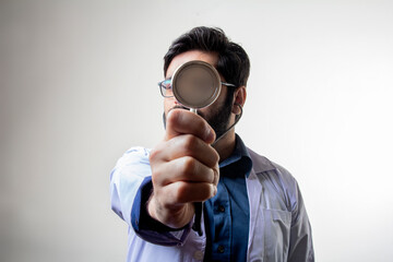 A doctor holding stethoscope pointing in front covering face