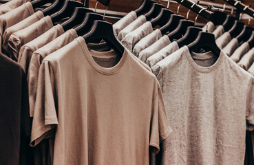 Close-up photo of olive colored soldier tactical t-shirts hanging on stand rack.