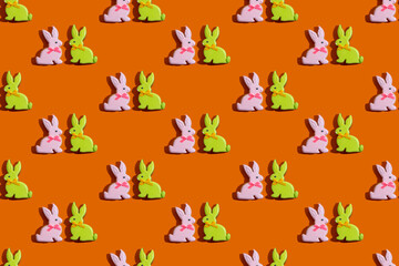 Bunny pattern. Seamless background. Colorful ornament for kids. Cute green pink rabbit couple cookie minimal composition isolated on vibrant orange wallpaper for boy or girl.