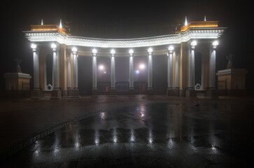 illuminated city columns in fog at night, Almaty, Kazakhstan