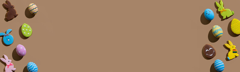 Easter banner. Festive frame. Holiday decoration. Greeting card. Colorful cute gingerbread biscuit bunny painted egg minimal composition isolated on beige brown copy space background.