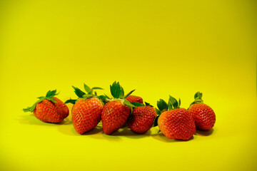 Set of strawberries on a yellow background.