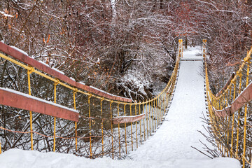 Suspension bridge in winter forest, selective focus