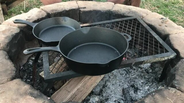 Cooking pork chops in Dutch oven cast iron skillets over an open campfire