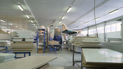 Interior of a furniture factory. Interior of large workshop of contemporary furniture factory with workplaces consisting of workbenches with working supplies.