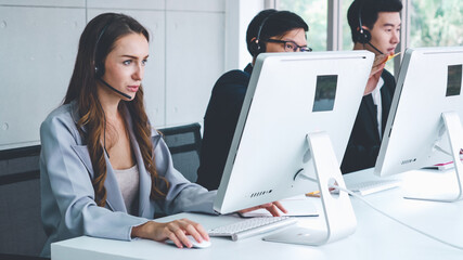 Business people wearing headset working in office to support remote customer or colleague. Call center, telemarketing, customer support agent provide service on telephone video conference call.
