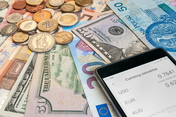 close up image of credit card, smartphone, coins and banknotes of different currencies