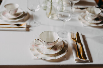 Vintage tea set and golden cutlery on a table at a restaurant.