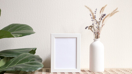 Poster with copy space. Mockup of a wooden frame with home plant ficus with vase with dried flowers. White, minimalism. copy space. Mock up design.