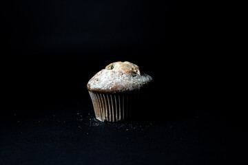Cupcake with  raisins on a black background close-up.