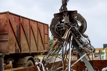 Loading scrap metal into a truck. Crane grabber loading metal rusty scrap in the dock