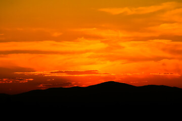 Atardecer en la Sierra de Guadarrama en Madrid, España. Cielo anaranjado con los últimos rayos del sol resaltando la silueta de las montañas ubicadas al norte de Madrid.