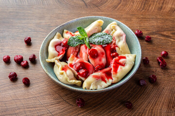 Dumplings with cherries, decorated with mint leaves. Ukrainian cuisine dishes.