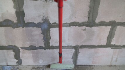 Roller application of waterproofing sealant to the wall. Applying a primer to a block wall.