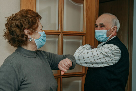 grandparents or seniors saluting each other with a mask in the coronavirus pandemic