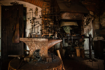 Blacksmiths tools, hammer and anvil in old Blacksmiths workshop, an ancient craft, old forge with a burned oud furnace with lots blacksmith's equipment