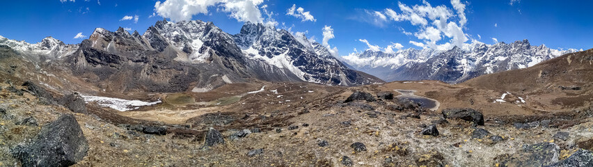 Fototapeta na wymiar Panoramic view of Kyajo Ri mountain peak (6151 meters) in Himalayas in Nepal near Lunden village and Renjo La Pass. White clouds begin to gather over the mountain valley. Everest base track route.