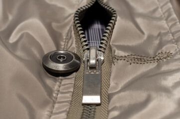 The lock with a zipper is close-up on the clothes of gray color. Zipper with lock. © Gudman