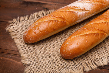 Fresh baguette bread on wooden background