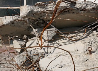 Demolitions: reinforced concrete wall destroyed with visible rusty armor