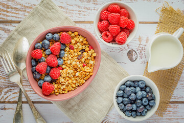 muesli with blueberries and raspberries on wooden table