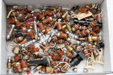 Old electronic lamps of different shapes. Small spiral light bulbs and gas-discharge lamps.