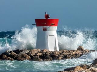 Vague s'écrasant contre un phare