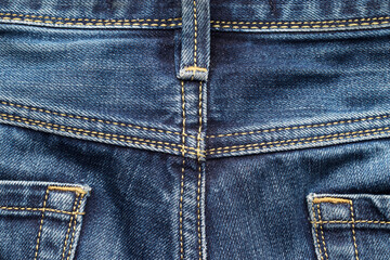 Back of blue jeans with pockets, belt loop, and seams as background