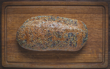Fresh natural sourdough bread on a wooden background. Loaf of whole grain bread