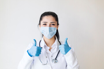 Covid19, coronavirus, healthcare and doctors concept. Portrait of optimistic female doctor assure everything be okay, thumb-up, wear medical mask to prevent catching virus, white coat