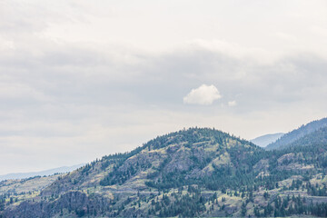 mountains in Okanagan valley and cloudy sky.