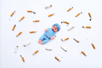 Baby doll with  cigarette butts and ashes on white