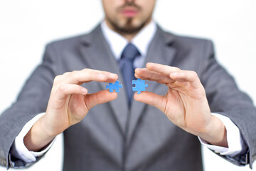 Fototapeta premium Hands fingers businessman team work holding and join pieces two jigsaw connecting couple puzzle piece for matching to goals target, success and start up new project in office.