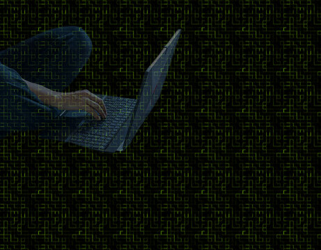 Mano de delincuente cibern&eacute;tico tecleando en un port&aacute;til en el internet profundo , con fondo digital negro y verde oscuro.