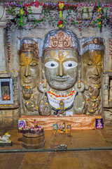 Obraz premium CHITTORGARH, INDIA - FEBRUARY 15, 2017: Trimurti - three faces of Lord Shiva in Samadhisvar (Samidheshwar) Temple at Chittor Fort in Chittorgarh, Rajasthan state, India