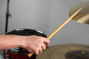 Professional drum set closeup. Man drummer with drumsticks playing drums and cymbals, on the live music rock concert or in recording studio   