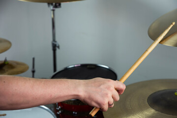 Professional drum set closeup. Man drummer with drumsticks playing drums and cymbals, on the live...