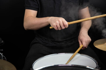 Professional drum set closeup. Man drummer with drumsticks playing drums and cymbals, on the live music rock concert or in recording studio   