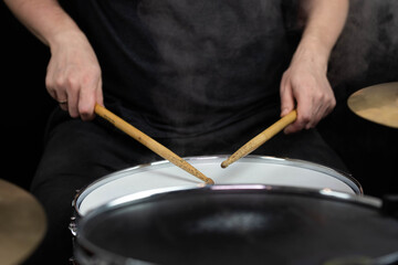 Professional drum set closeup. Man drummer with drumsticks playing drums and cymbals, on the live...