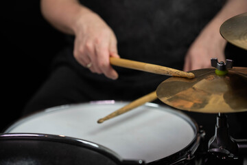 Professional drum set closeup. Man drummer with drumsticks playing drums and cymbals, on the live music rock concert or in recording studio   